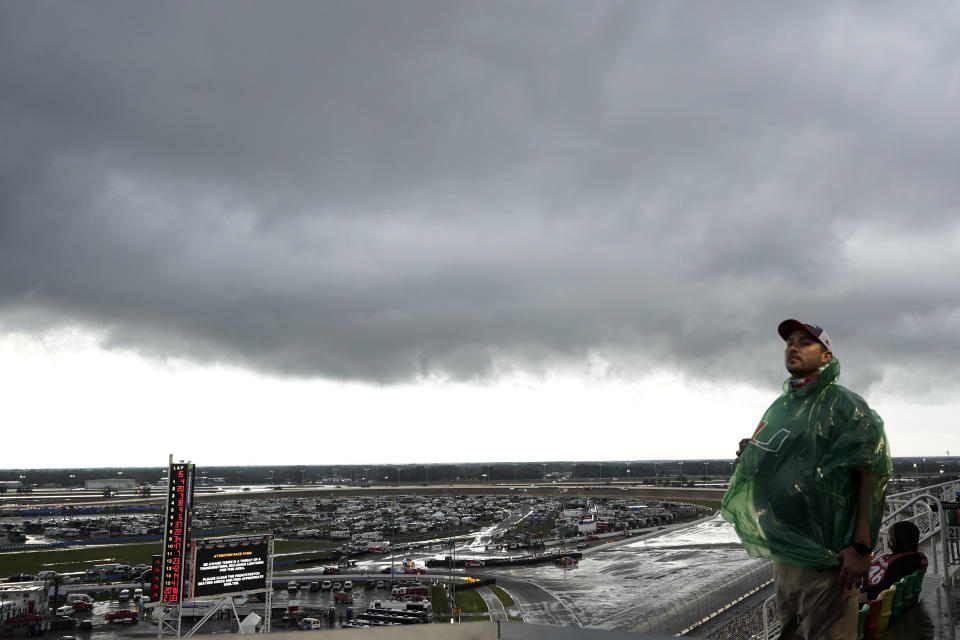 A fan waits during a weather delay in the NASCAR Daytona 500 auto race at Daytona International Speedway, Sunday, Feb. 14, 2021, in Daytona Beach, Fla. (AP Photo/Chris O'Meara)