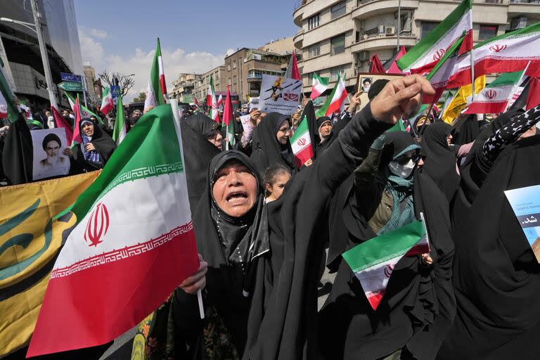 Una devota canta consignas mientras sostiene una bandera iraní durante una reunión antiisraelí después de la oración del viernes en Teherán, Irán, el viernes 19 de abril de 2024