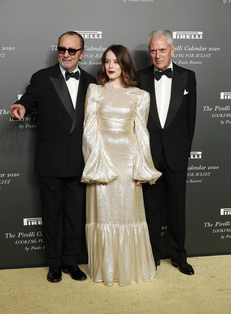 British actress Claire Foy, center, poses with Italian photographer Paolo Roversi, left, and Pirelli CEO Marco Tronchetti Provera, at the 2020 Pirelli Calendar event in Verona, Italy, Tuesday, Dec. 3, 2019. (AP Photo/Antonio Calanni)