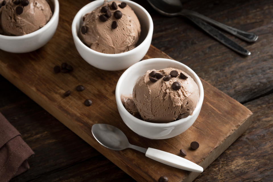 Chocolate ice cream on wooden background, copy space. Homemade vegan keto chocolate ice cream with chocolate chips - healthy summer dessert.