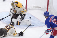 Boston Bruins goaltender Jeremy Swayman (1) is unable to stop a goal by New York Rangers left wing Artemi Panarin, not seen, as Rangers center Alex Wennberg (91) watches during the second period of an NHL hockey game, Thursday, March 21, 2024, in Boston. Bruins left wing Jake DeBrusk tries to defend at left. (AP Photo/Steven Senne)