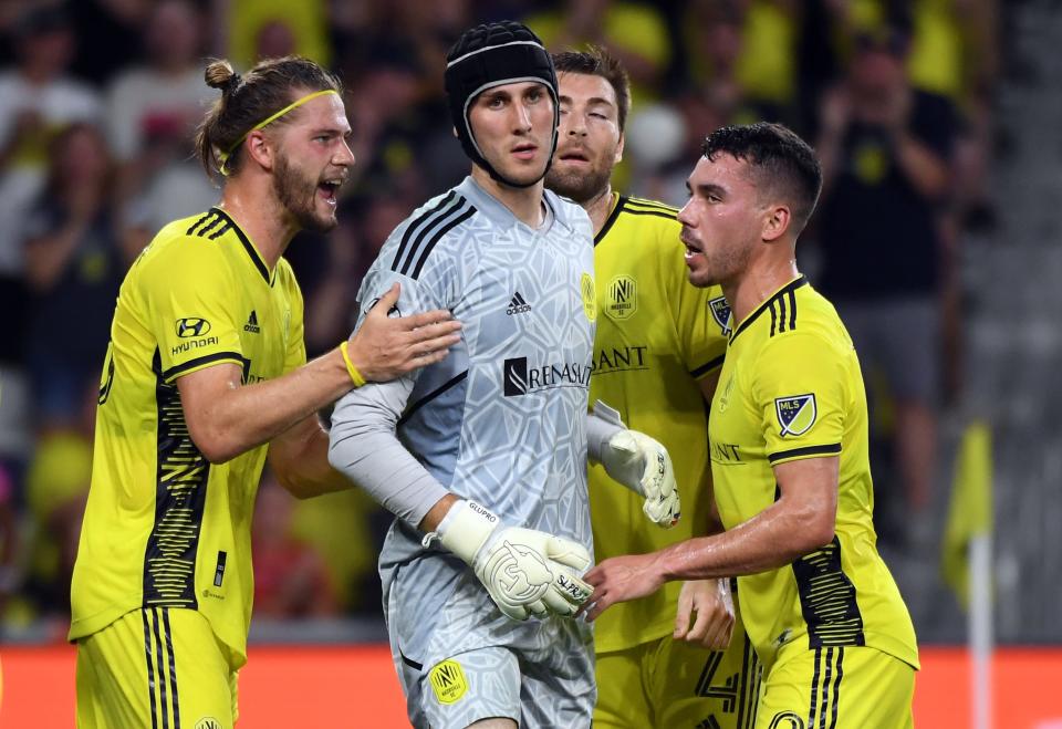 Jul 3, 2022; Nashville, Tennessee, USA; Nashville SC goalkeeper Elliot Panicco (30) is congratulated by defender Walker Zimmerman (25) defender Dave Romney (4) and defender Daniel Lovitz (2) after a save during the first half against the Portland Timbers at Geodis Park.