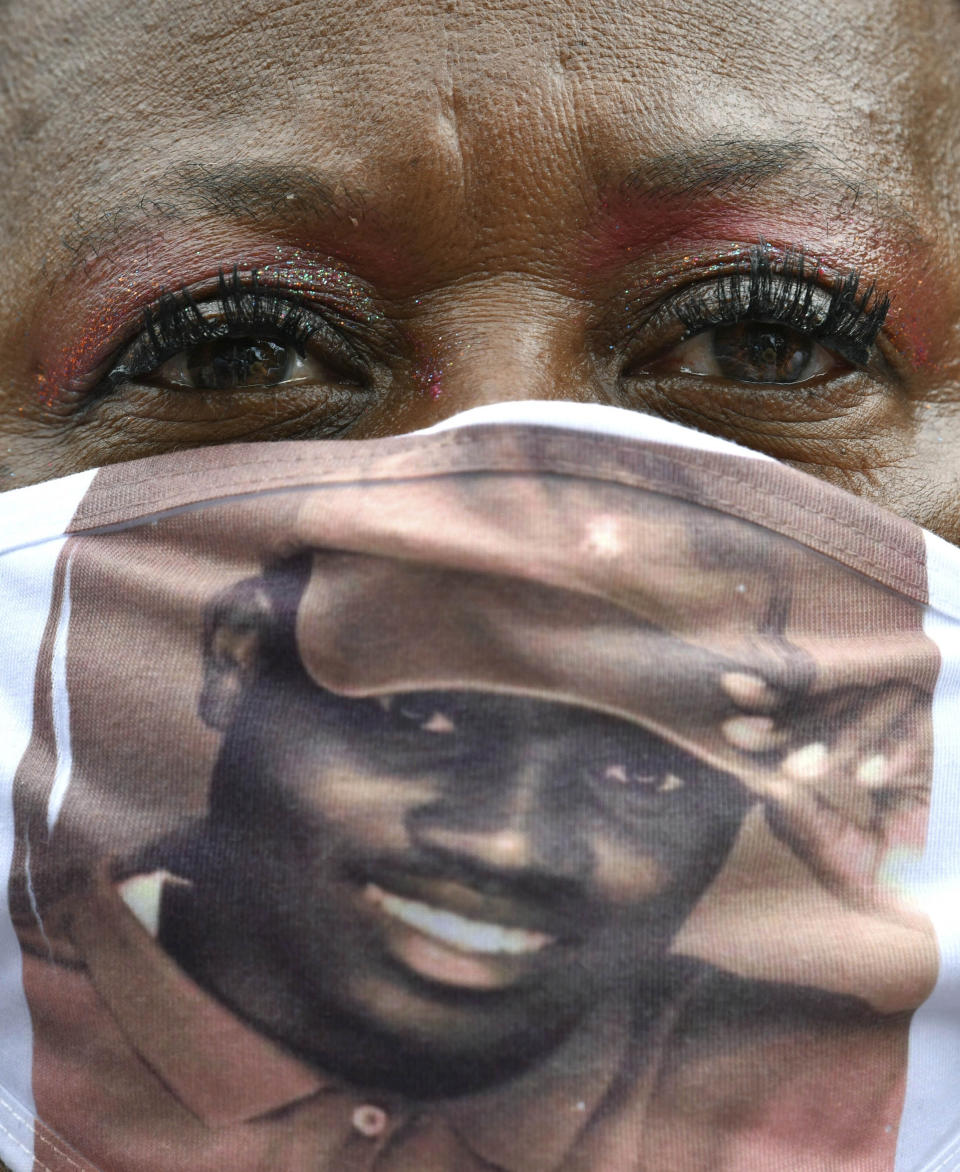 A protester with a photo of Ahmaud Arbery on a mask, gathers outside the Glynn County Courthouse during a rally to protest the shooting of Ahmaud Arbery, Saturday, May 16, 2020, in Brunswick, Ga. (Hyosub Shin/Atlanta Journal-Constitution via AP)