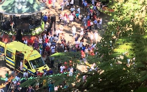 An ambulance attends the scene after a tree fell on a large crowd in the outskirts of Funchal - Credit: Catarina Nunes/Diario de Noticias da Madeira via AP