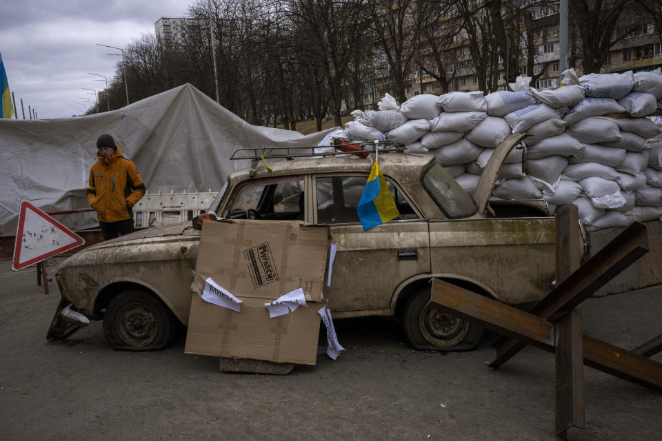 A militia man stands at a checkpoint set up on a road heading to the city of Kyiv, Ukraine, Saturday, March 5, 2022. Russian troops took control of the southern port city of Kherson this week. Although they have encircled Kharkiv, Mykolaiv, Chernihiv and Sumy, Ukrainian forces have managed to keep control of key cities in central and southeastern Ukraine, Ukrainian President Volodymyr Zelenskyy said Saturday. (AP Photo/Emilio Morenatti)