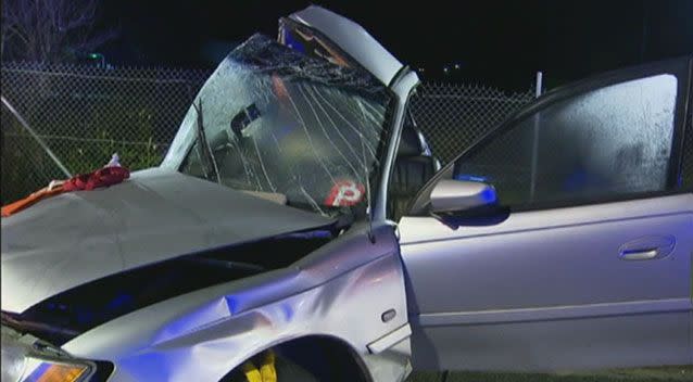 The silver Holden sedan is believed to have crossed a median strip and two lanes of oncoming traffic to slam into a pole. Pictures: 7 News