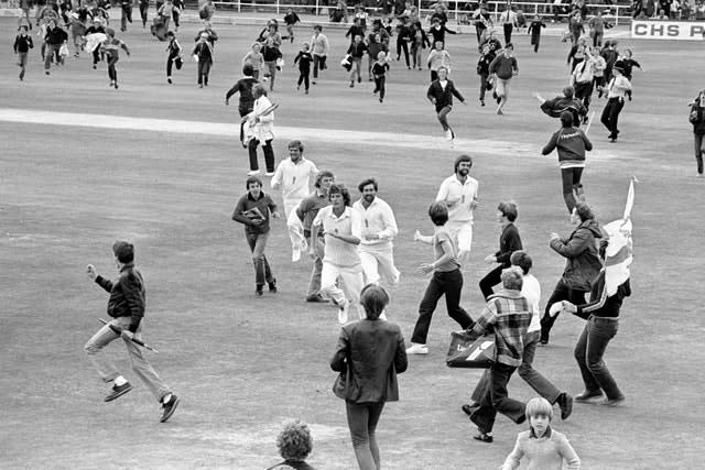 Willis (centre) leading the side off after England’s sensational victory over Australia in the Third Cornhill Test of The Ashes at Headingley as fans run on to celebrate