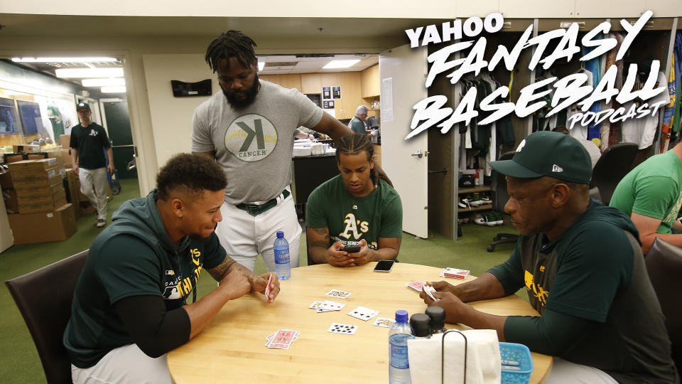 Frankie Montas, Khris Davis and special assistant Rickey Henderson of the Oakland A's play cards in the clubhouse.