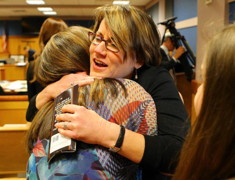 With her testimony over, a relieved Stacey Kalberman (center), former executive director of the state ethics commission, gets a hug from her friend Terri Cohen in her lawsuit at the Fulton County Courthouse on Thursday, April 3, 2014, in Atlanta. Closing arguments will start on Friday. Kalberman claims she was forced from her position as executive director of the state ethics commission after investigating Governor Nathan Deal's campaign. (AP Photo/Atlanta Journal-Constitution, Curtis Compton) MARIETTA DAILY OUT; GWINNETT DAILY POST OUT; LOCAL TV OUT; WXIA-TV OUT; WGCL-TV OUT