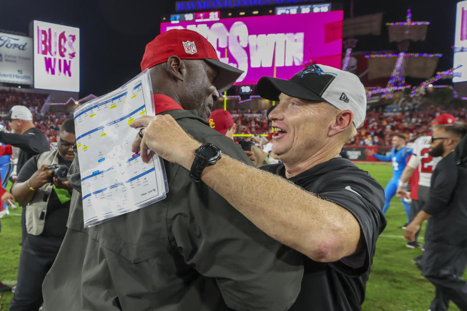 Tampa Bay Buccaneers head coach Todd Bowles, left, greets Carolina Panthers interim head coach Chris Tabor after the Buccaneers win in an NFL football game Sunday, Dec. 3, 2023, in Tampa, Fla. (AP Photo/Mark LoMoglio)