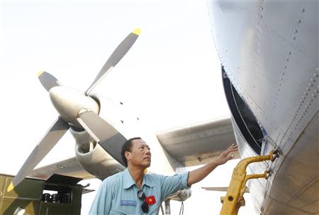 Captain Vu Duc Long boards an aircraft AN-26 belonging to Vietnam Air Force before departing for a search and rescue mission of the missing Malaysia Airlines flight MH370, at a military airport in Ho Chi Minh city March 11, 2014. REUTERS/Kham