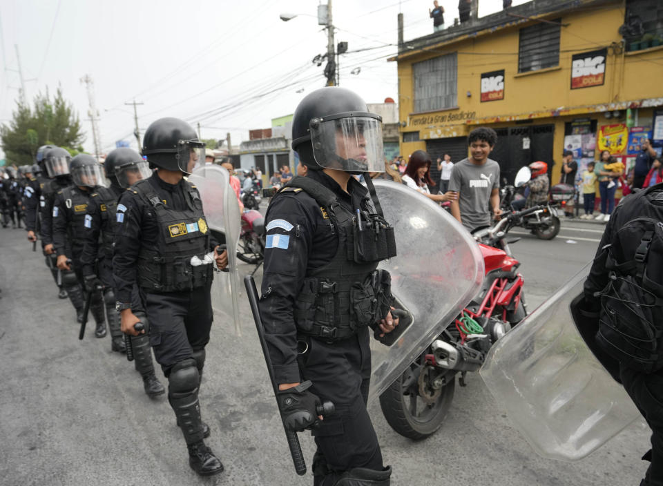 Policías antimotines marchan por una carretera bloqueada por manifestantes en Ciudad de Guatemala el martes 10 de octubre de 2023. Las protestas en respaldo del presidente electo Bernardo Arévalo reclaman por las acciones de la fiscalía y judiciales contra su partido para suspenderlo por presuntamente haberse constituido con firmas falsas. (AP Foto/Moisés Castillo)