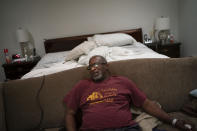 Mike Bishop sits in his bedroom on Thursday, Oct. 8, 2020, in Byram, Miss. In early July, Bishop was hit by COVID-19. Bishop was living alone at home, in a big suburban house. He'd wake up confused at 2 a.m. when Bonnie Bishop, his wife, wasn't beside him. (AP Photo/Wong Maye-E)
