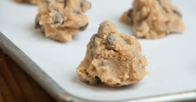 A pan of freshly prepared homemade chocolate chip cookie dough sits on the counter waiting to go into the oven.