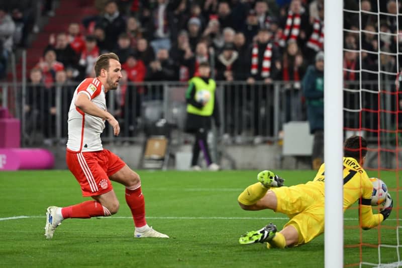 Bayern Munich's Harry Kane (L) gets a shot away from Leipzig goalkeeper Janis Blaswich during the German Bundesliga soccer match between Bayern Munich and RB Leipzig at Allianz Arena. Sven Hoppe/dpa