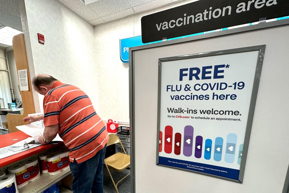 A sign for flu and COVID-19 vaccinations is displayed at a pharmacy store in Palatine, Illinois, on Sept. 13, 2023.