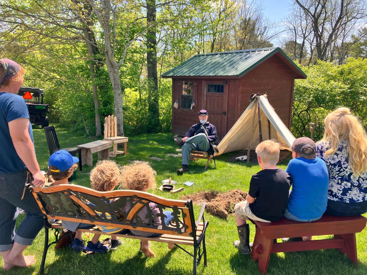 Jahn Cauvel presents to Maurissa Gruneisen and Amanda Durham and their children. He said the message of his performance at Cabin at Willow Hollow was aimed at commemorating sacrifices others made for the American freedoms that exist today.