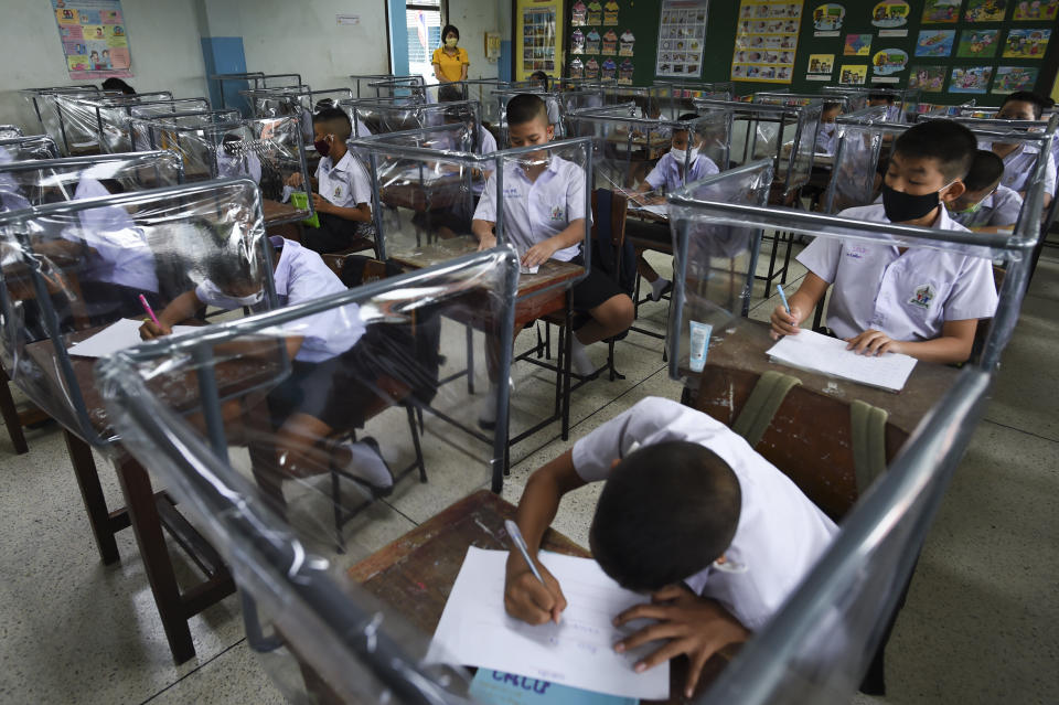 Students sit at desks with plastic sheet shields during the first day of school after the Thai government eased isolation measures and introduced social distancing to prevent the spread of the coronavirus at Watpichai school in Bangkok on July 1.