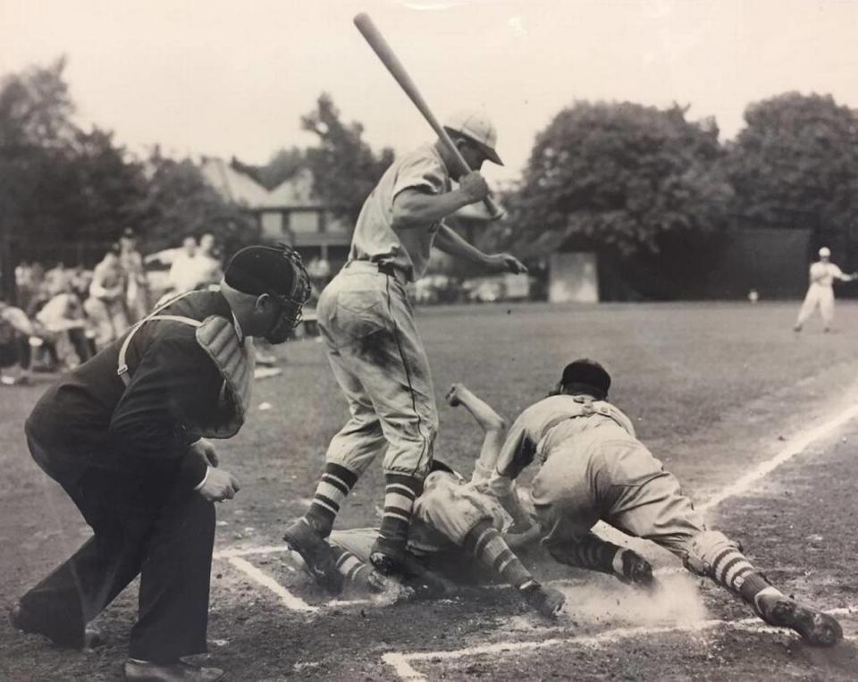Barney Elser slides in home as a member of the Belleville Township High School baseball team in 1949. The batter, jumping out of the way, is Bob Goalby, who would go on to 11 Pro Golfers Tour wins including the 1968 Masters championship. The BTHS team won the state championship that season. Elser, a sophomore, set a standing record with three doubles in an Illinois title game.