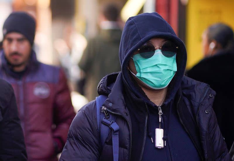 A pedestrian wears a protective face mask in central London