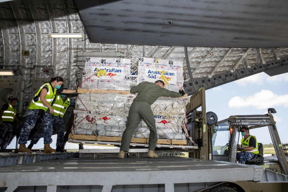 In this photo provided by the Australian Defence Force, personnel unload emergency aid supplies at Tonga's Fuaʻamotu International Airport, near Nukuʻalofa, Thursday, Jan. 20, 2022, after a volcano eruption. U.N. humanitarian officials report that about 84,000 people — more than 80% of Tonga's population — have been impacted by the volcano's eruption. (LACW Emma Schwenke/Australia Defence Force via AP)