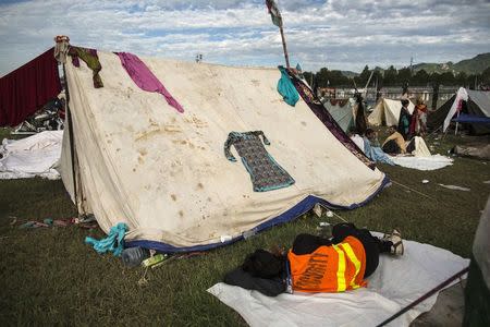 An anti-government protester sleeps near a tent in front of the President House during the Revolution March in Islamabad September 3, 2014. REUTERS/Zohra Bensemra