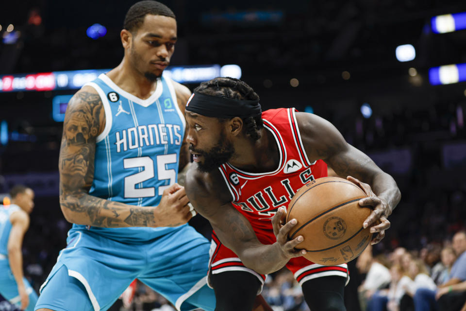 Chicago Bulls guard Patrick Beverley, right, looks to pass the ball past Charlotte Hornets forward P.J. Washington (25) during the first half of an NBA basketball game in Charlotte, N.C., Friday, March 31, 2023. (AP Photo/Nell Redmond)