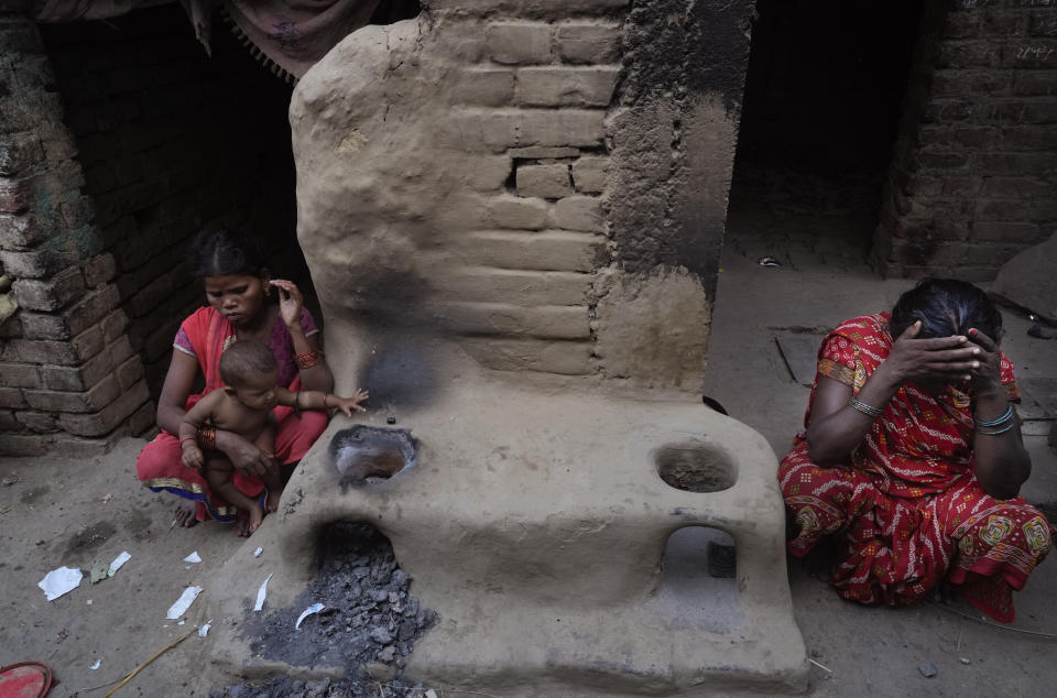 Women from impoverished families sit near the mud stoves for cooking outside their huts on the outskirts of Patna, in the Indian state of Bihar, on May 11, 2024. (AP Photo/Manish Swarup)