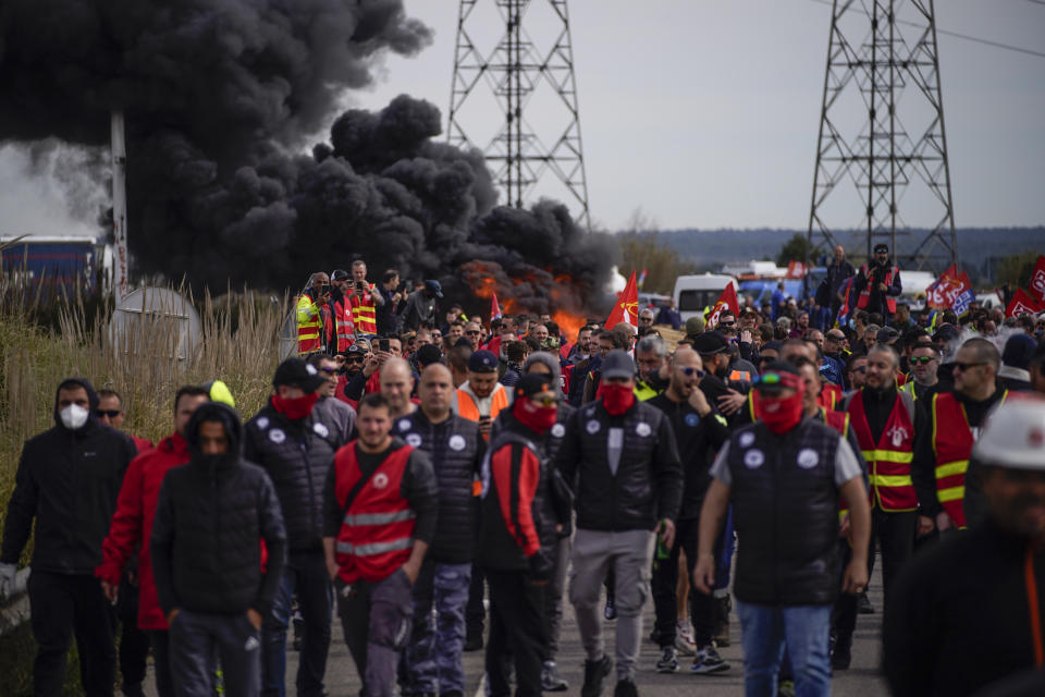 Oil workers on strike block the access to an oil depot in Fos-sur-Mer, southern France, Tuesday, March 21, 2023. The bill pushed through by President Emmanuel Macron without lawmakers' approval still faces a review by the Constitutional Council before it can be signed into law. Meanwhile, oil shipments in the country were disrupted amid strikes at several refineries in western and southern France. (AP Photo/Daniel Cole)
