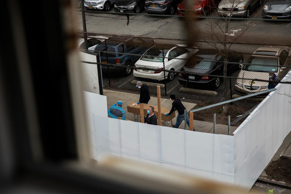 Workers transport a casket-sized box near the morgue set up outside Wyckoff Heights Medical Center in Brooklyn on March 30. | Benjamin Norman for TIME