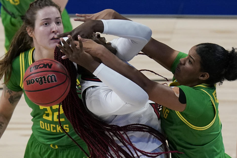 Louisville forward Olivia Cochran, left, is blocked by Oregon forward Nyara Sabally, right, during the first half of a college basketball game in the Sweet Sixteen round of the women's NCAA tournament at the Alamodome in San Antonio, Sunday, March 28, 2021. (AP Photo/Eric Gay)