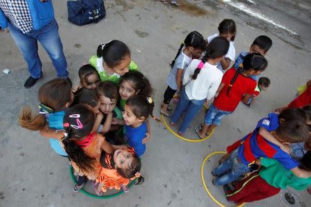 Syrian refugee children play as volunteers entertain them inside a housing compound in Sidon, southern Lebanon June 12, 2016. REUTERS/Ali Hashisho