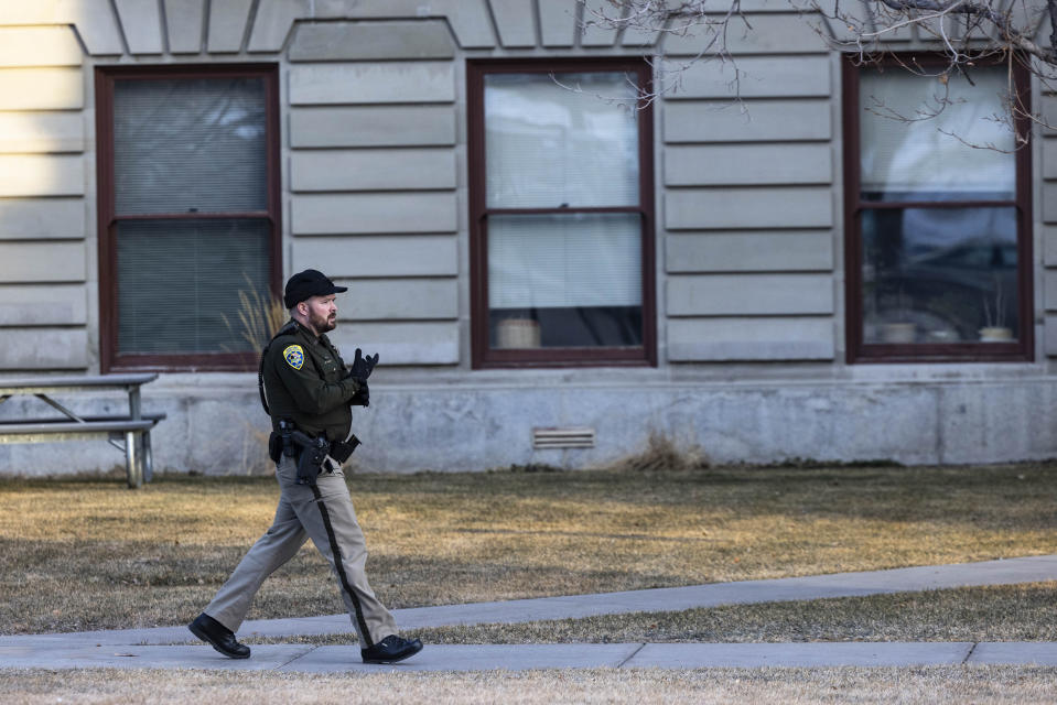 Montana High Patrol Trooper Brandon Uhl walks the perimeter of the Montana State Capitol, Wednesday morning, Jan. 3, 2023, after a bomb threat. (Thom Bridge/Independent Record via AP)