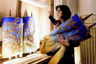 In this Saturday, Feb. 1, 2020, photo, Rabbi Jacqueline Mates-Muchin removes a Torah scroll from the ark, a cabinet that houses scrolls of the Hebrew Bible, while preparing for Shabbat morning service at Temple Sinai in Oakland, Calif. In September 2017, on the first day of Rosh Hoshana, the Jewish new year, a security guard found an anti-Semitic message scrawled on an outdoor wall of Temple Sinai. “Since 2017, the congregation has been looking to try to feel safe,” she said. “It’s another layer that we always have to be conscious of.” (AP Photo/Noah Berger)