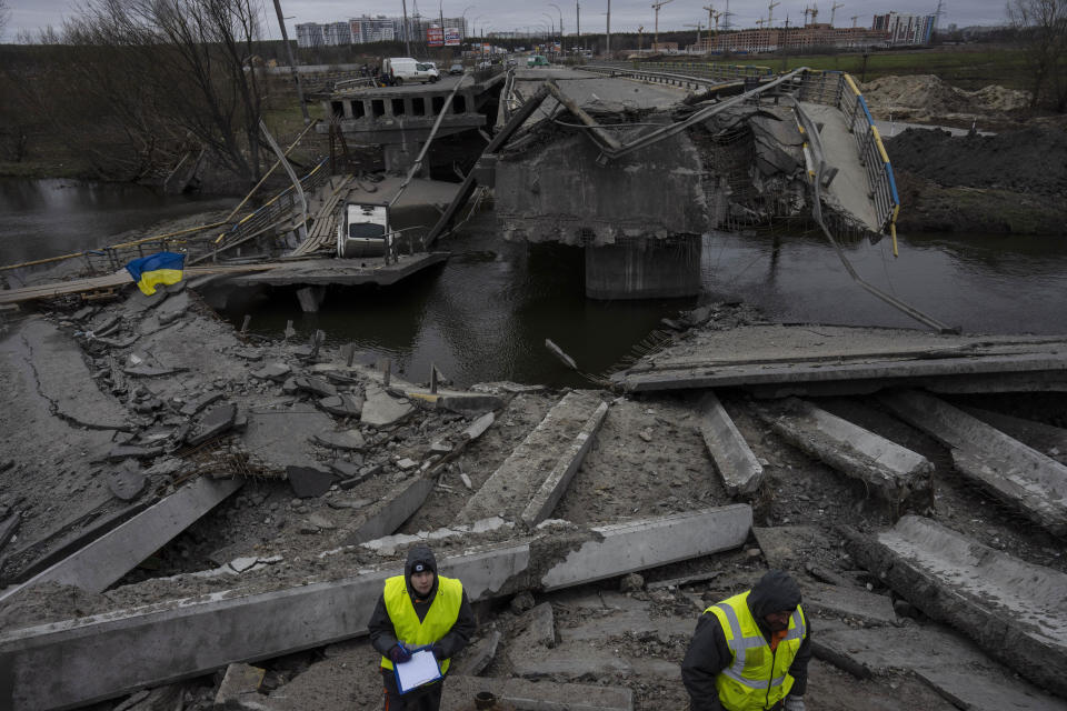 Engineers inspect the state of destruction of the bridge that connects Kyiv with Irpin, Ukraine, Wednesday, April 13, 2022. (AP Photo/Rodrigo Abd)