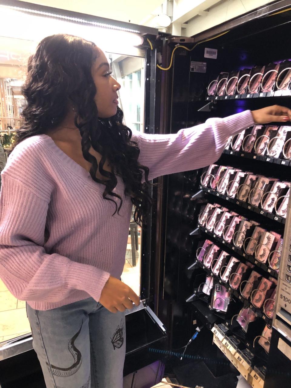 Mikayla Walker checks the stock in the machine that sells her Mikayla Janee Collection products at Circle Centre Mall.
