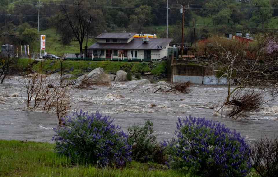 Rough water rolls past a riverside building.