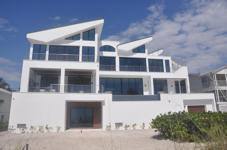 The new home on Bonita Beach stands out from the others due to the sail like forms that create the roof. This property used to have one of the most dated, older homes from the 1970s and now it has the most modern look.