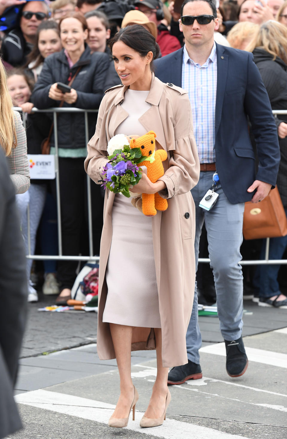 Meghan stunned in a custom Brandon Maxwell cream midi shift dress, layered with a Burberry Bishop trench coat. Photo: Getty