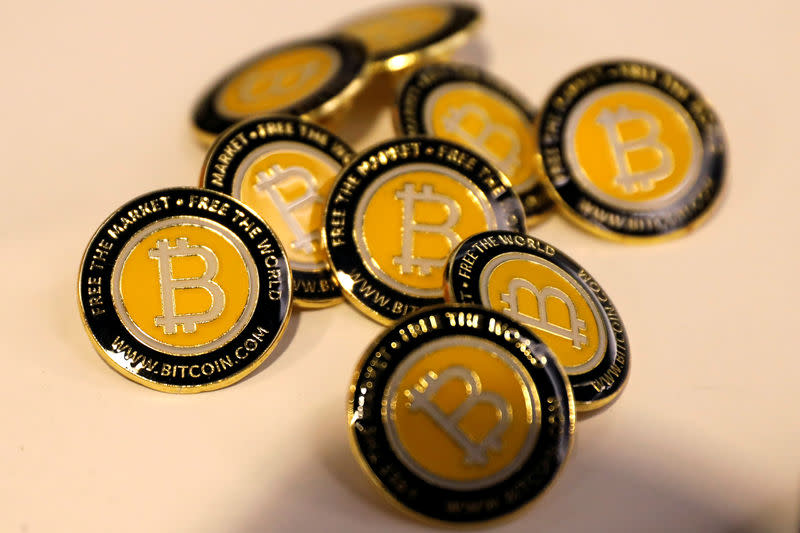 FILE PHOTO: Bitcoin.com buttons are seen displayed on the floor of the Consensus 2018 blockchain technology conference in New York City, New York, U.S., May 16, 2018. REUTERS/Mike Segar/File Photo