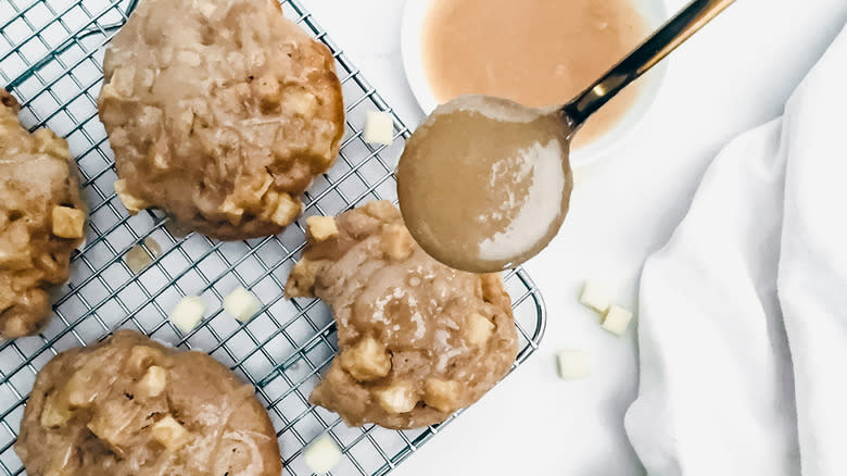 adding maple glaze to apple fritters