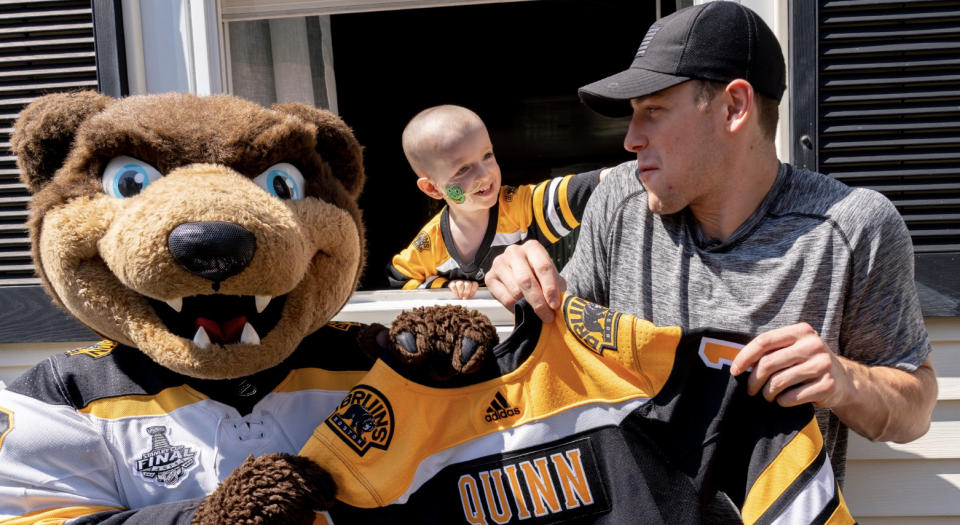 Boston's Charlie Coyle (right) poses with the Bruins' mascot Blades (left) and three-year-old Quinn Waters (centre). (Twitter//@NHLBruins)