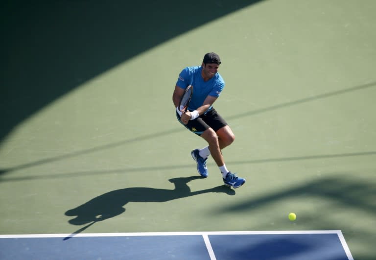 Tunisian Malek Jaziri hits a return to Russian Mikhail Youzhny during their ATP tennis match on the first round of the Dubai Duty Free Tennis Championships on February 22, 2016