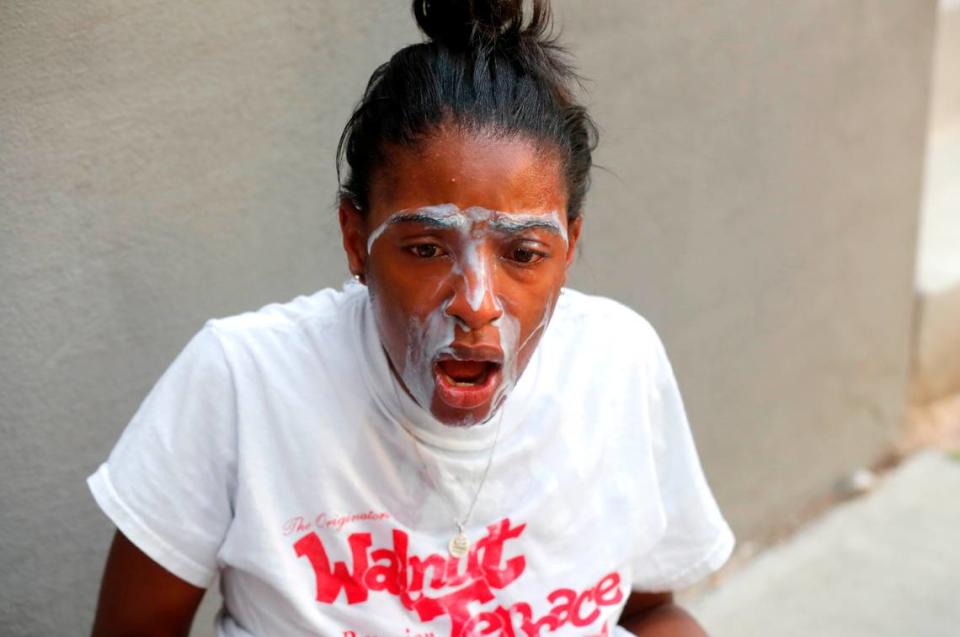 Jessica Peacock of Raleigh tries to get the tear gas out of her eyes during a protest in downtown Raleigh, N.C. Saturday, May 30, 2020.