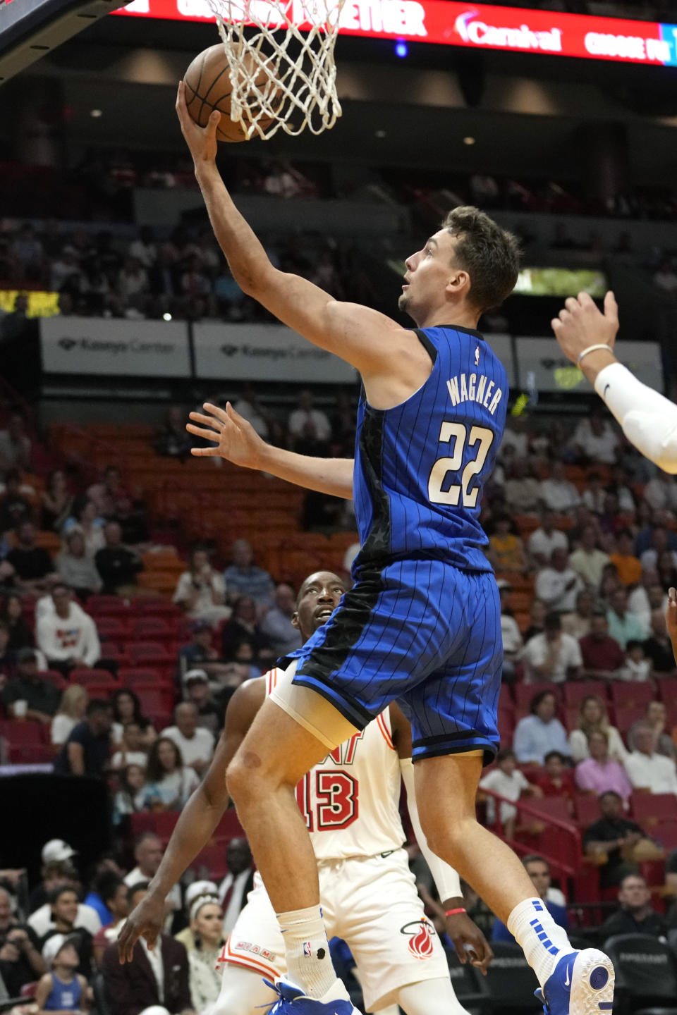 Orlando Magic forward Franz Wagner (22) goes to the basket over Miami Heat center Bam Adebayo (13) during the first half of an NBA basketball game, Sunday, April 9, 2023, in Miami. (AP Photo/Lynne Sladky)