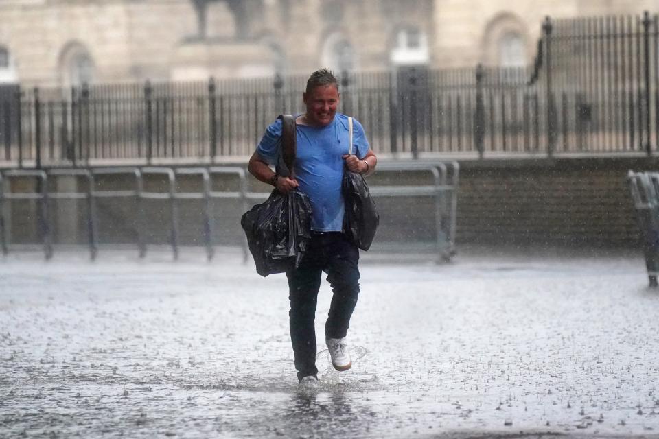 A man walks through flood water in in central London. Thunderstorms are being forecast (PA) (PA Wire)