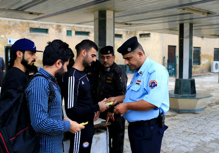 An Iraqi Policeman inspects tickets of passengers before boarding a train to Fallujah, the newly resurrected service to the city, at a railway station in Baghdad, Iraq November 7, 2018. Picture taken November 7, 2018. REUTERS/Thaier al-Sudani
