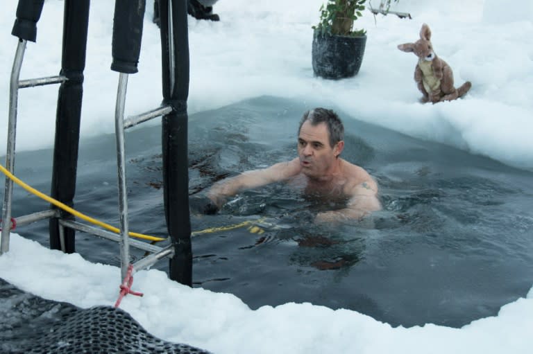 This handout photo taken on June 19, 2018 and released by the Australian Antarctic Division (AAD) on June 21 shows Barry Balkin taking a dip in a swimming hole prepared at the Casey research station as researchers welcome the winter solstice