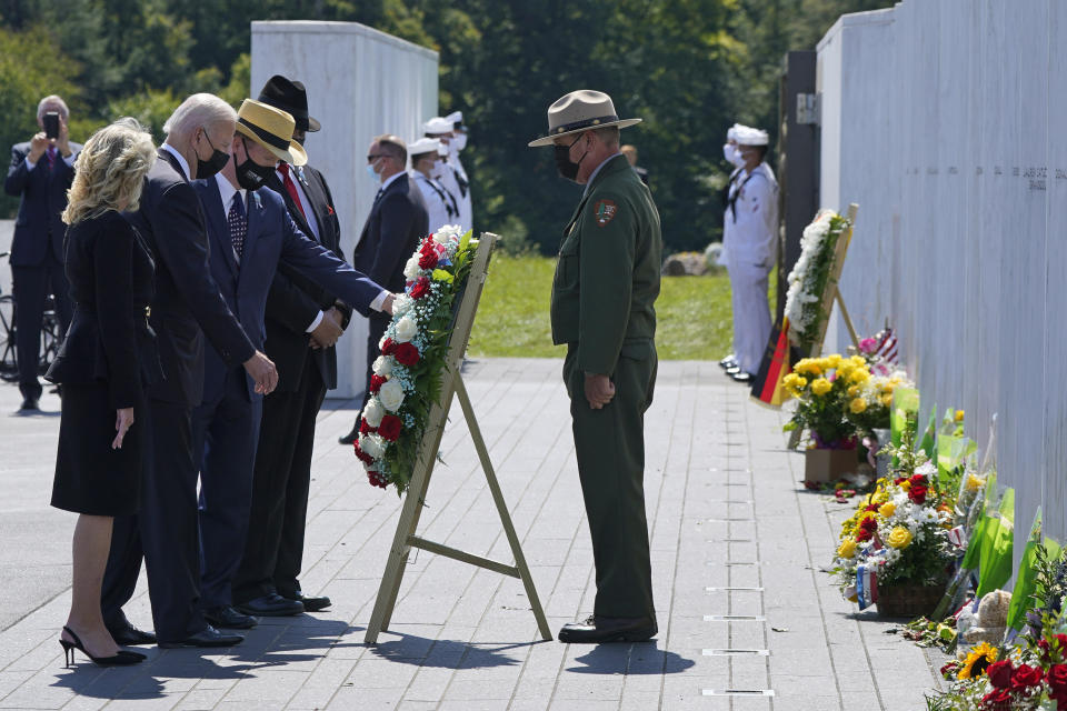 President Joe Biden, second from left, and First Lady Jill Biden, left, help place a wreath at the Wall of Names at the Flight 93 National Memorial with Gordon Felt, third from left, who lost his brother Edward Felt in the crash of Flight 93 in Shanksville, Pa., Saturday, Sept. 11, 2021. (AP Photo/Gene J. Puskar)