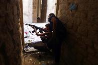 Ahmad Abu Layl, a 15 year-old fighter from the Free Syrian Army, aims his weapon as his father stands behind him in Aleppo September 10, 2013. REUTERS/Hamid Khatib